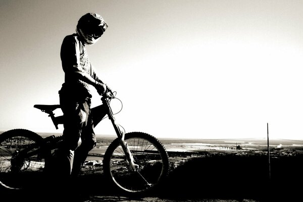 A cyclist in a helmet on the horizon background