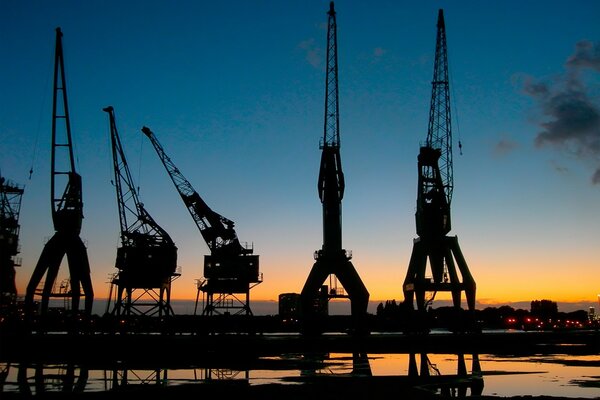 Kräne im Hafen vor dem Hintergrund des Sonnenuntergangs