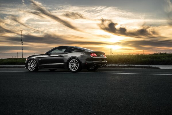 Foto schwarzer Ford avant bei Sonnenuntergang Hintergrund