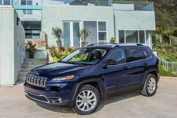 Jeep azul en el patio de una casa de campo