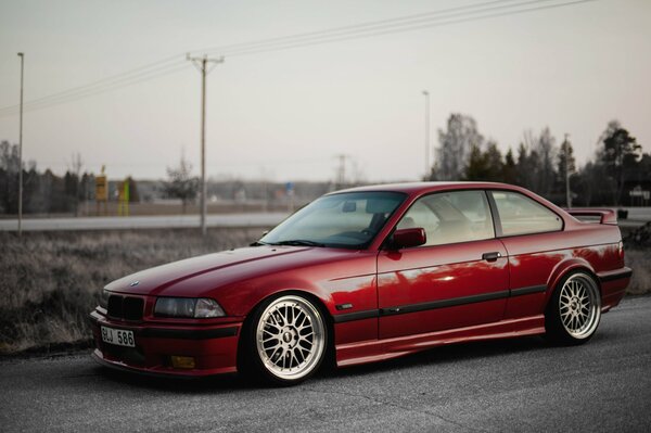 Red BMW E36 3 series slowed down on the road