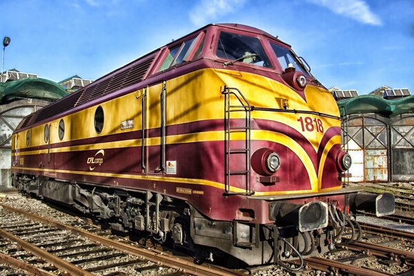 Art ferroviaire avec une locomotive inhabituellement peinte près de la gare