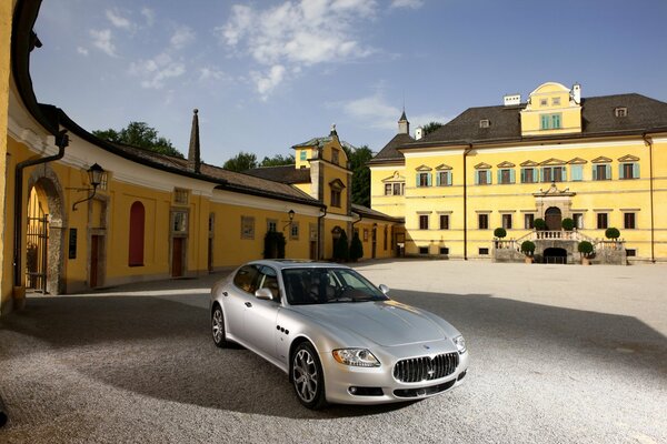 Maserati quattroporte couleur argent dans la cour de la maison