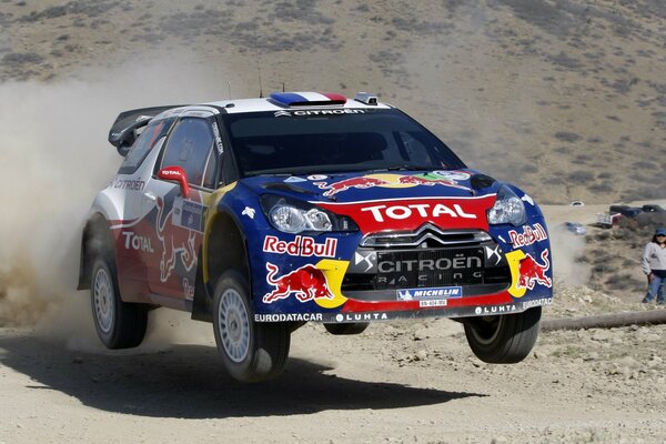 Citroen rally participant flies along the road kicking up dust