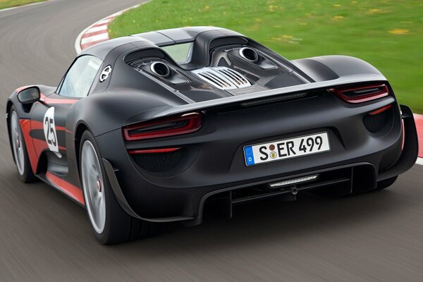 El Porsche Spider negro pasa un giro en la pista de carreras