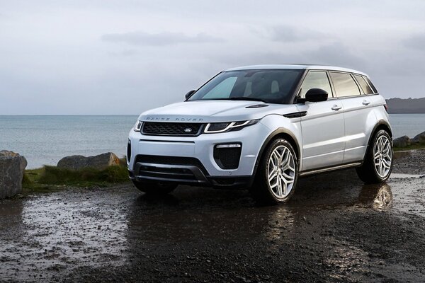 Range rover silver color, behind the sea