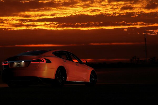 El coche de Tesla en medio de una hermosa puesta de sol