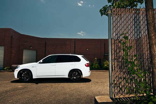 BMW x-5 blanc crossover à côté du bâtiment