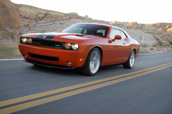 On the highway - a tomato-colored sports car, with lights on