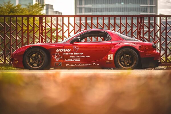 Against the background of a red fence - a sports tuned Mazda