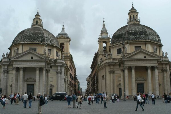 Turistas en la calle de la ciudad cerca de dos edificios arquitectónicos