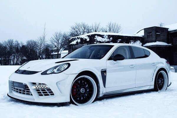 Biały samochód Porsche na śniegu
