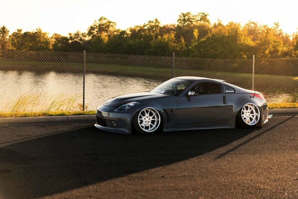 A nissan 350z car passes near a reservoir