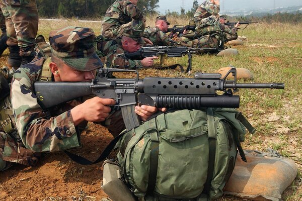 Soldaten mit Maschinengewehren und Rucksäcken auf der Deponie