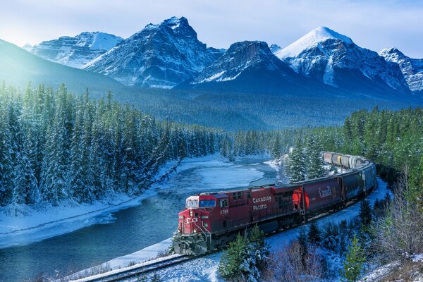 The province of Canada is Alberta. The train rushes through the snow-covered forest