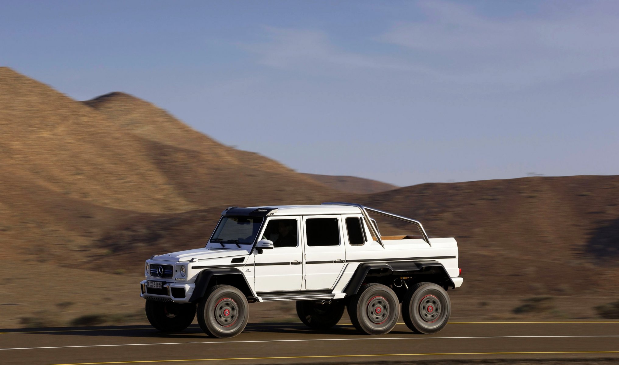 mercedes-benz g63 amg 6x6 auto blanco vista lateral en movimiento día suv