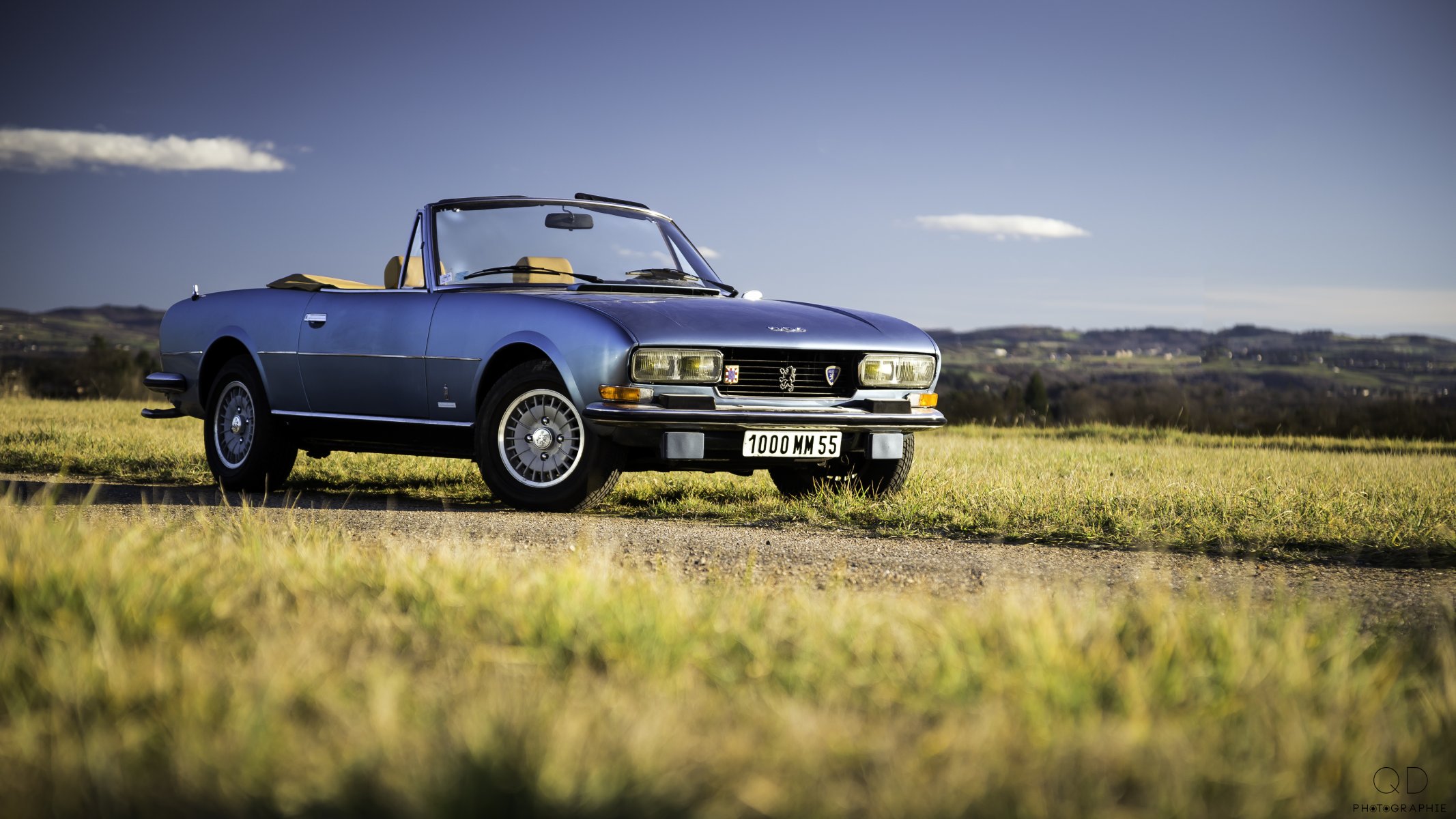 peugeot 504 convertibile v6 strada erba colline nuvole cielo blu