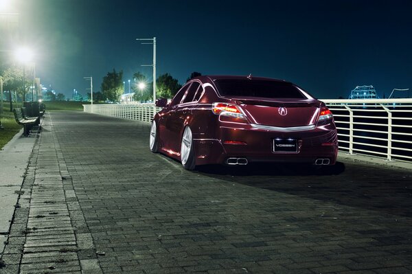 Honda Accord Borgoña en el fondo de la ciudad de la noche