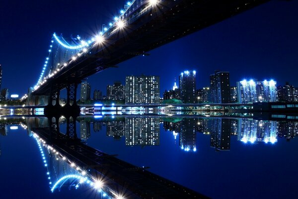 Ciudad nocturna y puente y reflejo de espejo en el agua