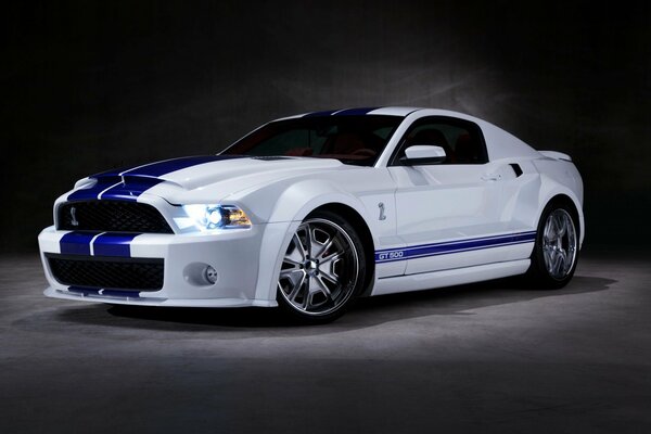 White Shelby GT 500 with blue stripes on a dark background