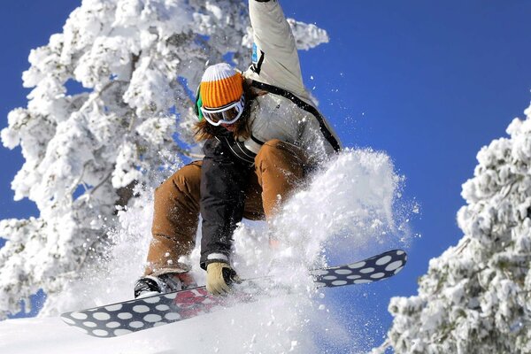 Vuelo de invierno de una niña en una tabla de snowboard