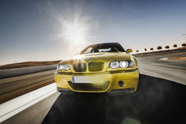 Goldener BMW auf der Straße. sonniger Tag