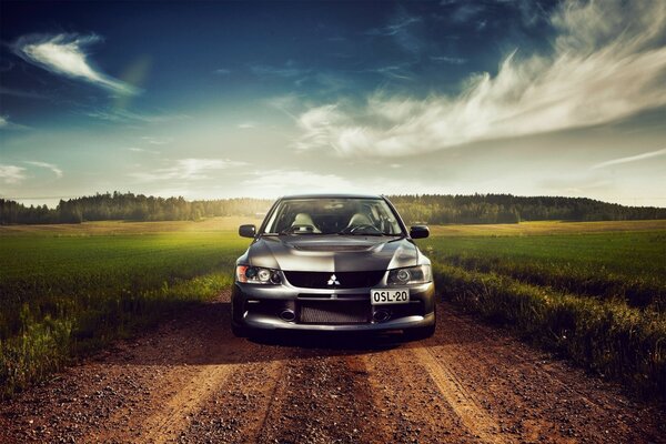 Mitsubishi car on the ground against the background of clouds