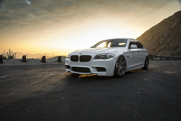 Voiture blanche de marque BMW au coucher du soleil