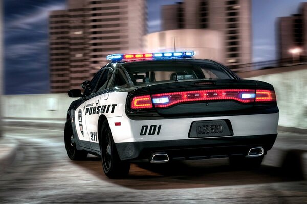 A police car is driving through the night city