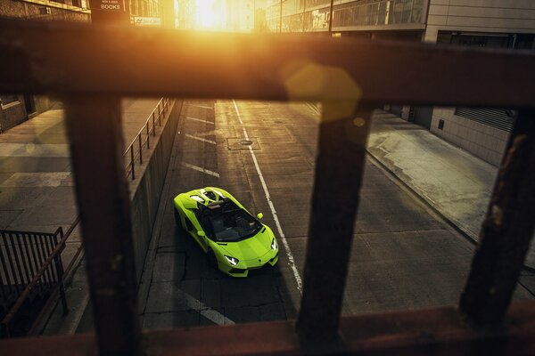 Grüner Supersportwagen in der Stadt bei Sonnenuntergang