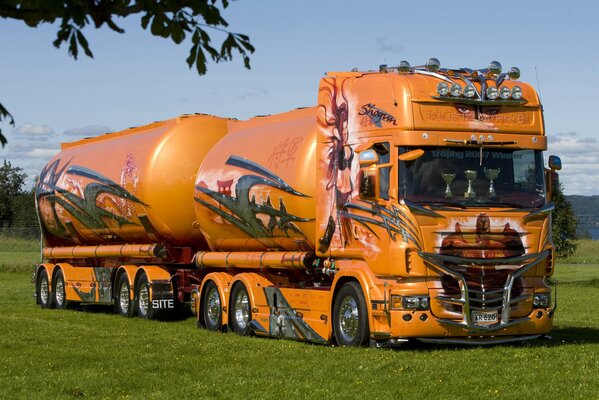 Camión naranja Scania en el campo