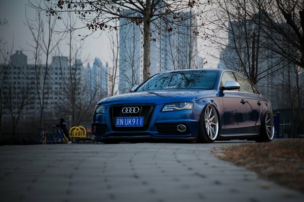 Audi a6 turns blue against the background of the autumn city