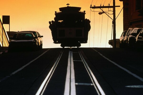 Die Stadt. Straßenbahn. Sonnenuntergang. Autos