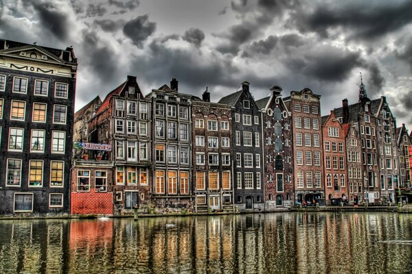 Las pintorescas casas de Ámsterdam a orillas del canal bajo un sombrío cielo de plomo