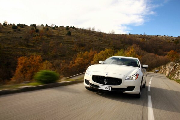 Maserati bewegt sich rasant im Herbst in der Landschaft