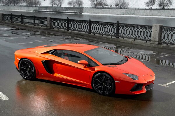 Lamborghini rojo en el puente cerca del río