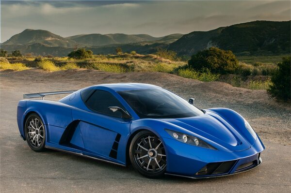 Supercar bleu sur la route sur fond de montagnes russes