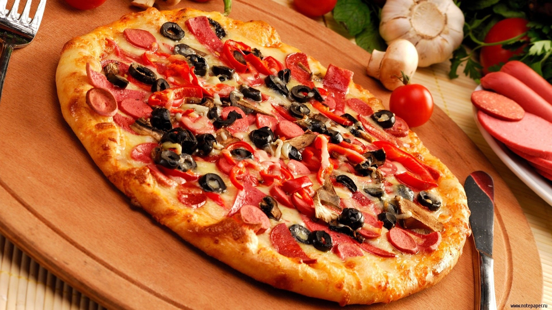 comida foto masa pizzero salchicha ajo esquina aceitunas mesa tabla cuchillo condimentos pizza tomates aceitunas