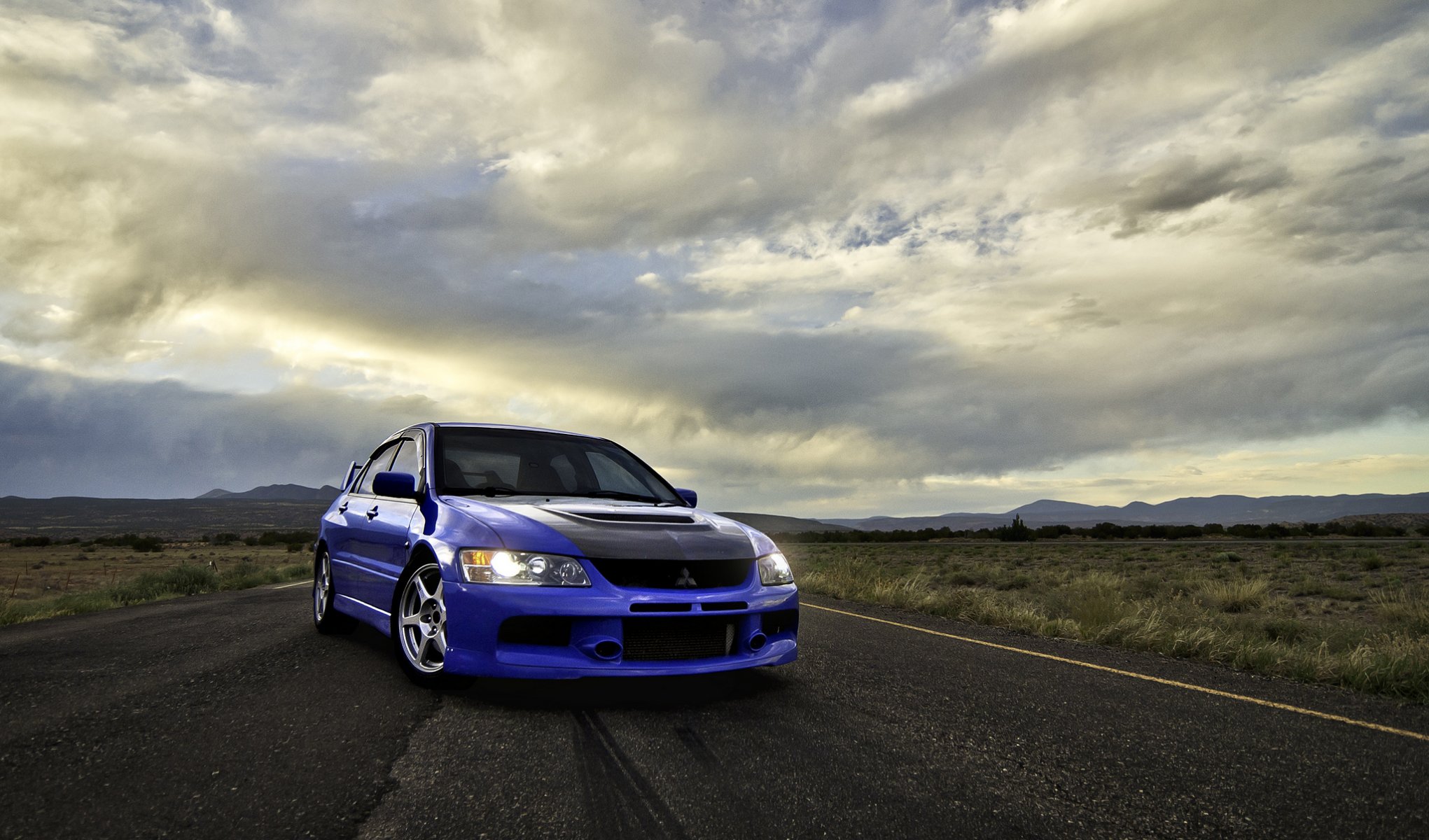 mitsubishi lancer evolution viii blu mitsubishi lancer evolve vista frontale strada nuvole