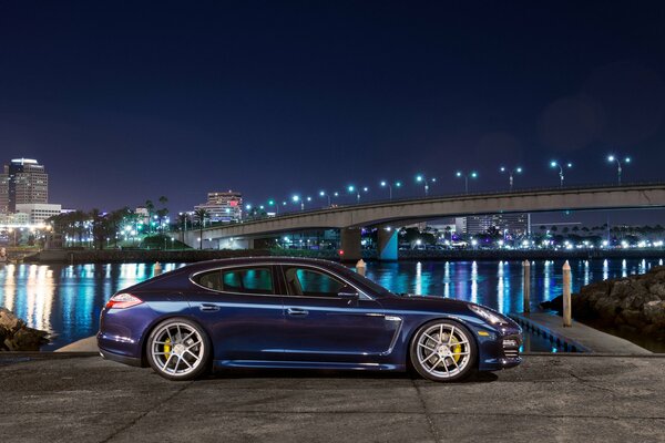 Azul porsche panamera s vista lateral de la ciudad nocturna