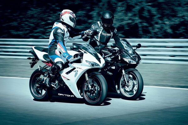 Two men on a white and black motorcycle communicate