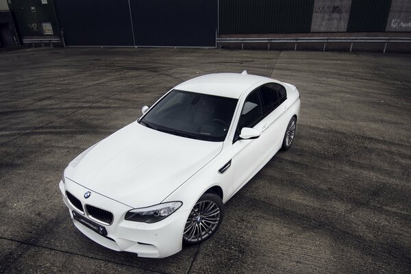 Une voiture blanche de la marque bmw se trouve sur le terrain