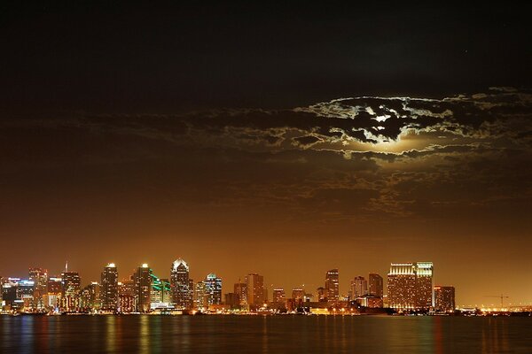 The lights of the night city are reflected in the sky