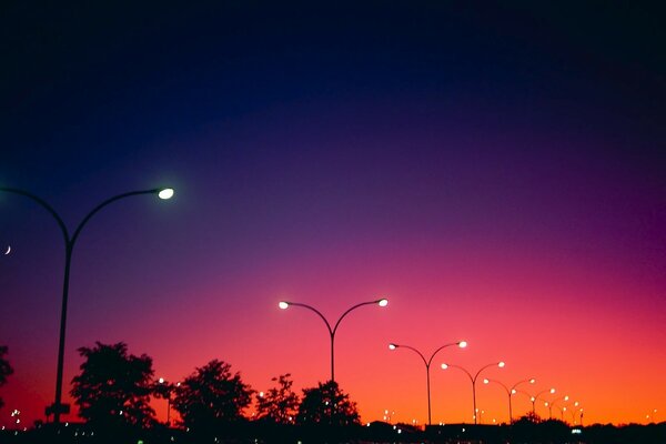 Luces encendidas en el fondo de una puesta de sol roja