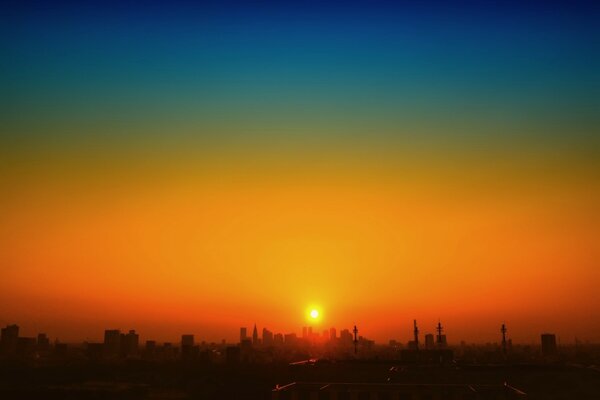 Le matin, le soleil regarde à travers les gratte-ciel