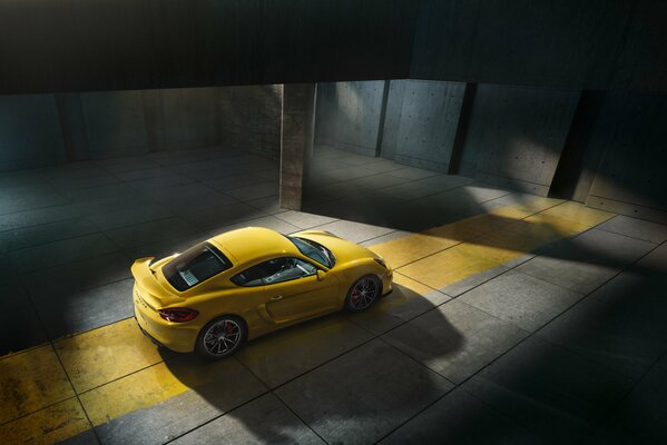 Porsche Cayman gelb im Halbdunkel