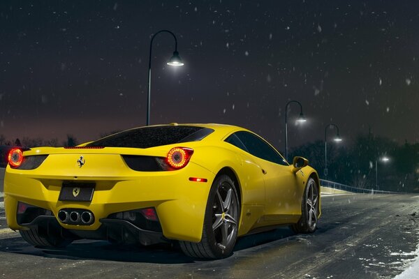 Schicker gelber Ferrari auf dem Hintergrund des nachtverschneiten Himmels