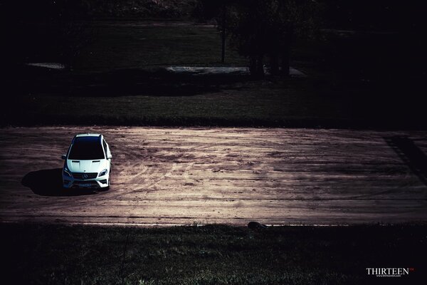 Foto del autor del automóvil Mercedes-Benz de color nieve, parado solo en la carretera