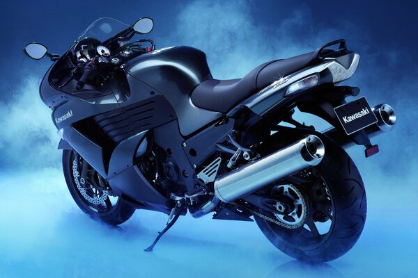 Kawasaki zzr-1400 sport bike stands in the fog on a blue background