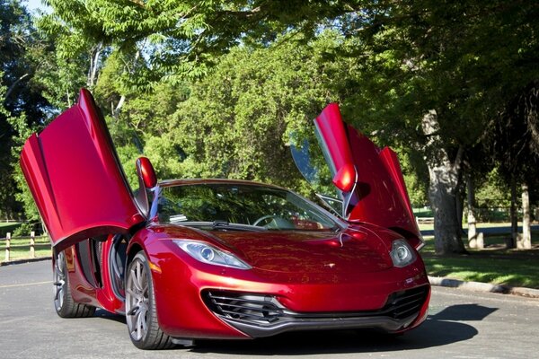 Автомобиль красный mclaren с поднятыми дверями